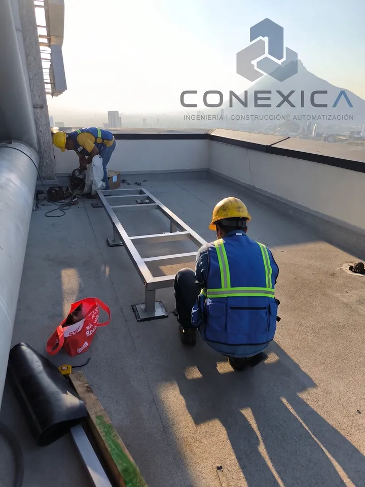 Base metálica para equipo montada en azotea mientras personal trabaja