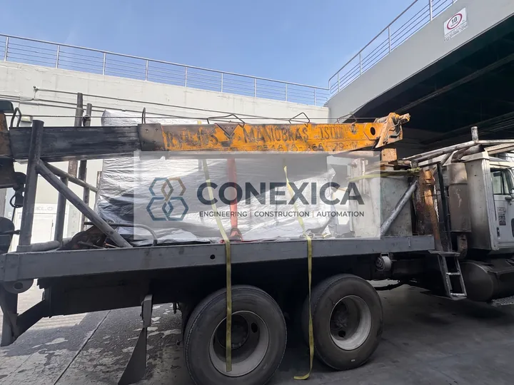 Camión con grúa transportando un equipo cubierto