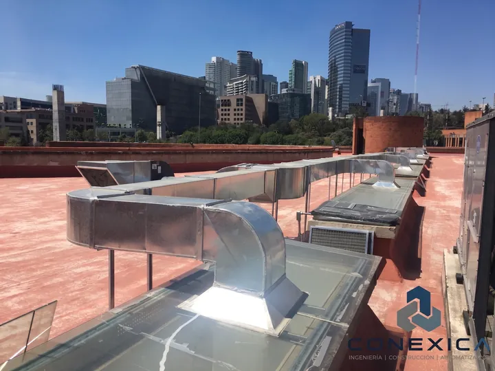 Ductos de ventilación metálicos instalados en azotea con vista a edificios