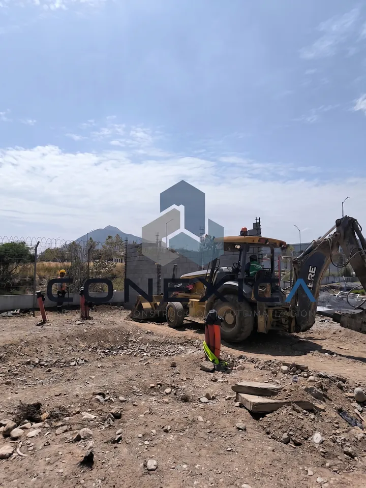 Retroexcavadora trabajando en un terreno con cerro al fondo